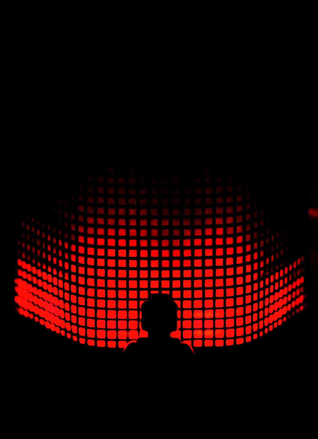 a-person-standing-in-front-of-a-red-light-wicvc9u7ope